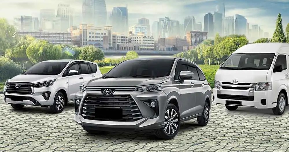 Barisan kendaraan keluarga Toyota (MPV dan van) dengan latar belakang pemandangan kota modern dan taman